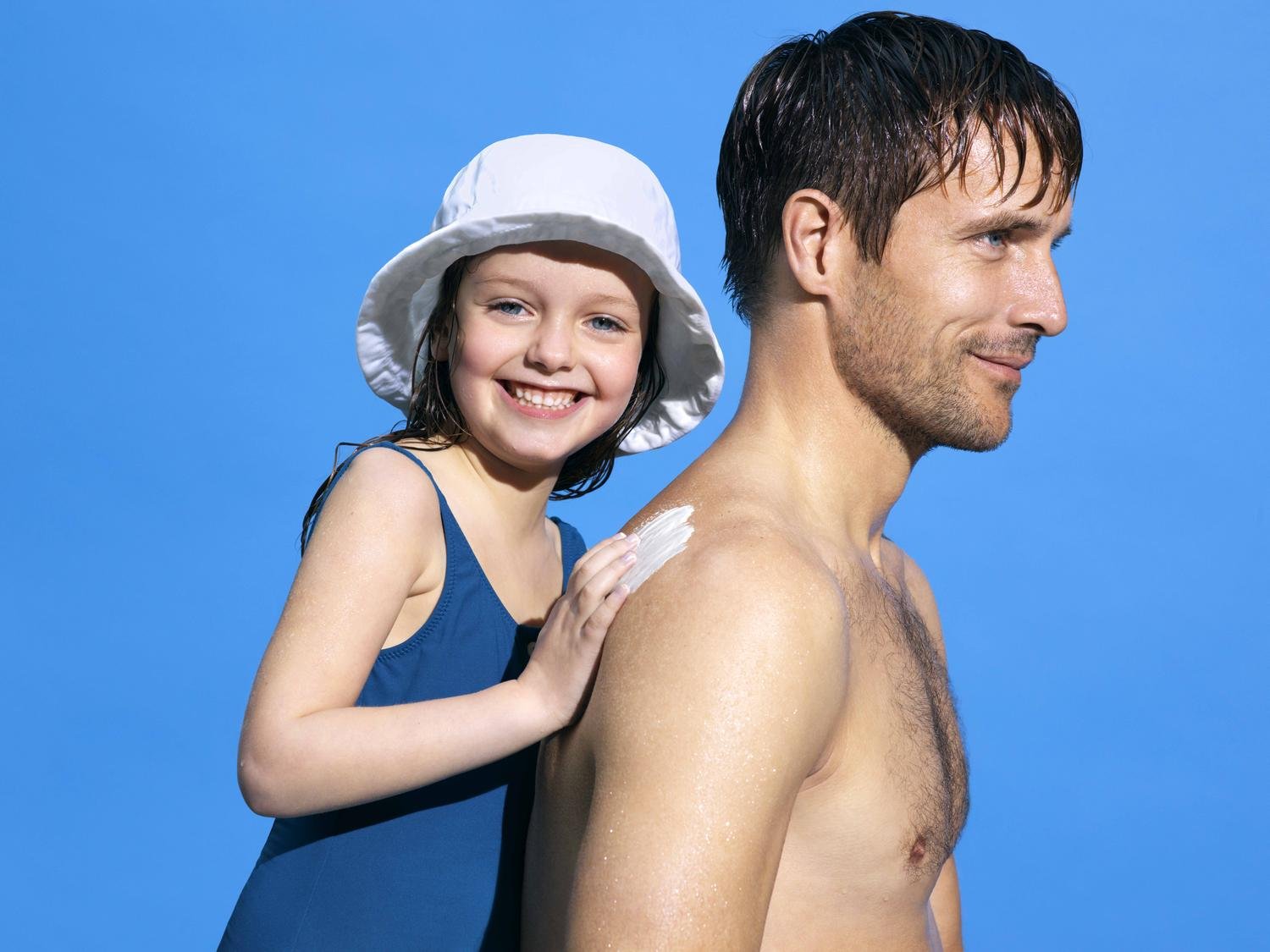 Una ragazza che spalma la crema sulle spalle di un ragazzo